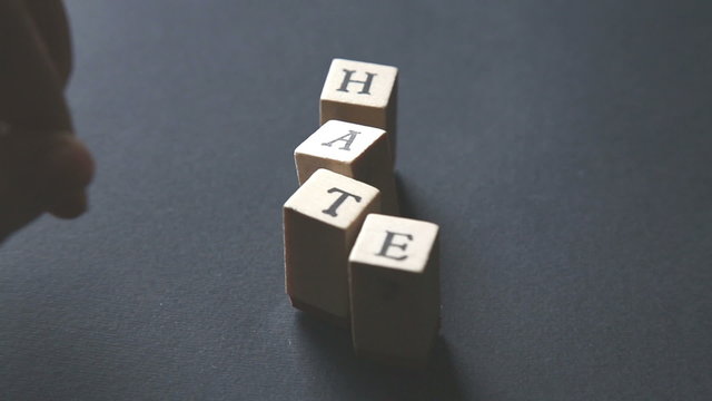 playing and typing the word "hate" with alphabet stamps