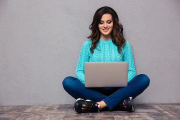 Woman using laptop computer on the floor