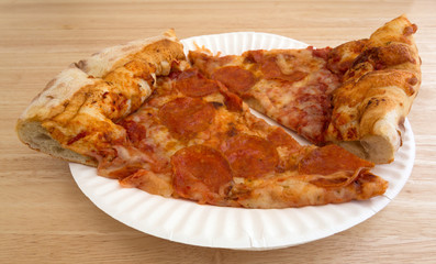 Two slices of pepperoni pizza on a paper plate