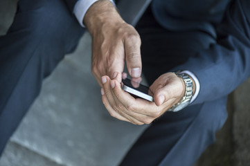Close up of a businessman using mobile smart phone