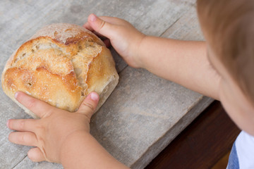 baby holding fresh bread in hand