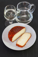 cheese on white dish with white wine on black background