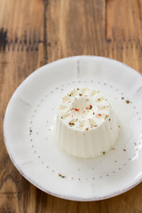 fresh cheese on white plate on brown wooden background