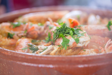 shrimps with rice in sauce in ceramic dish