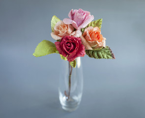 Colorful paper handmade roses on grey background