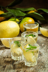 Carbonated lemonade with lemon slices and mint on an old wooden