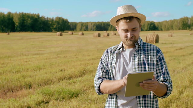 Young farmer using tablet computer in field 