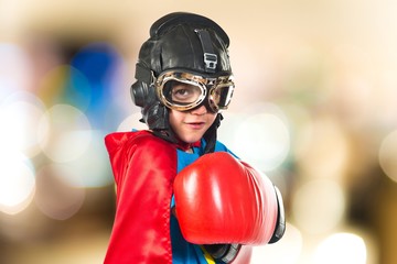 Confident child dressed like superhero with boxing gloves