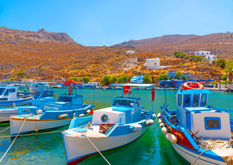 Fototapeta na wymiar traditional fishing boats docked at the port of Vathi village in Kalymnos island in Greece