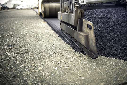 Industrial Pavement Truck Laying Fresh Asphalt, Bitumen During Road Works. Construction Of Highways And Road Works