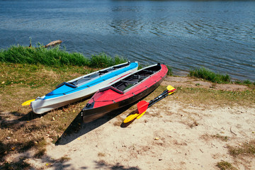 Empty kayaks on the shore of the river.