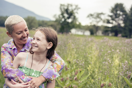 A mature woman and a young girl in a wildflower meadow. 