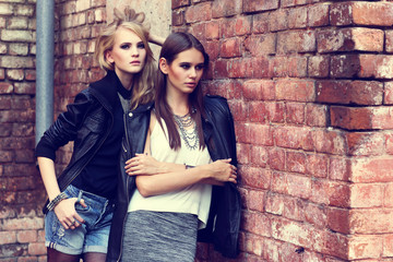 Two young fashion women posing outdoor.