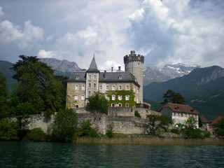 Castle with lake, surrounding by mountains.