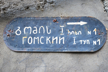 Old signboard with the name of the Gomi deadlock No. 1 on Russian and Georgian