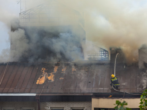 Firefighter at work on extinguishing the fire on roof