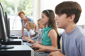 Group Of Elementary Pupils In Computer Class With Teacher