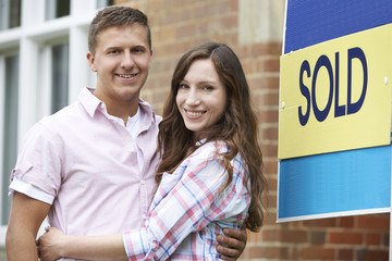 Excited Couple Outside New Home Together