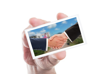 Real estate sale handshake on paper card