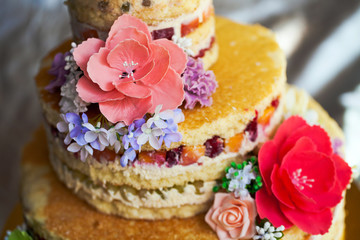 Wedding cake. Naked handmade cake rustic, decorated with roses.