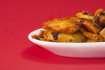 Octopus with paprika on a white plate, also known as Galician oc