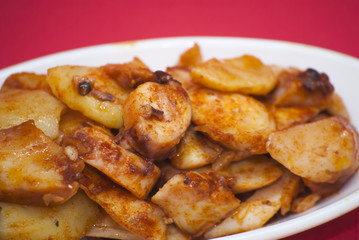 Octopus with paprika on a white plate, also known as Galician oc