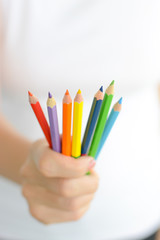 Fototapeta premium Woman holding colorful pencils in hand