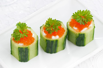 cucumber tartlets with cream cheese and red caviar, top view