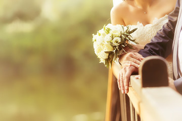 Bride and groom's hands with wedding rings (soft focus), filter