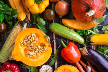 Fresh vegetables scaterred on a rustic dark textured table. Autu