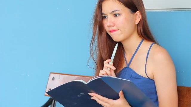 Portrait of thai adult beautiful girl Read and think in university.