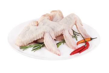 Сырые куриные крылья с перцем на тарелке без фона