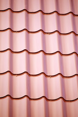 Construction material. Fragment of red metal roof as background closeup
