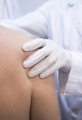 Dooctor surgeon examines patient shoulder arm injury