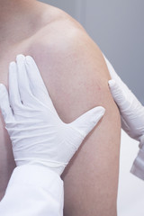 Dooctor surgeon examines patient shoulder arm injury