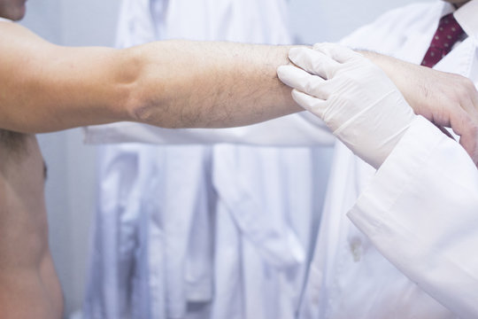 Dooctor surgeon examines patient shoulder arm injury
