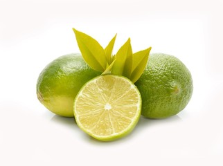 Group of whole and cut fresh limes with leaves