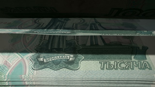 An extreme closeup of russian ruble banknotes flipping through in a counting machine