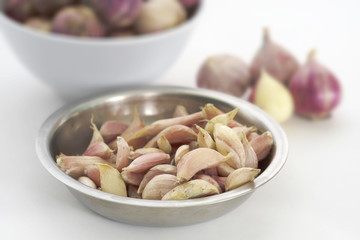 Garlic/Close up fresh garlic in metal dish on white paper background.