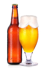 Glass and bottle of beer with drops isolated on white