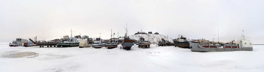 Fishing boats at rest on stands on the shore. Panorama.