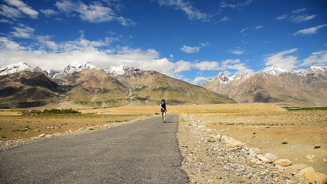 Smart Asian woman covered her face walking on lonely road in sunny day, Padum, Zanskar valley, India 