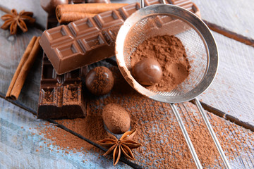 Chocolate sweets with powder on wooden background