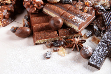 Chocolate sweets with powder on wooden background