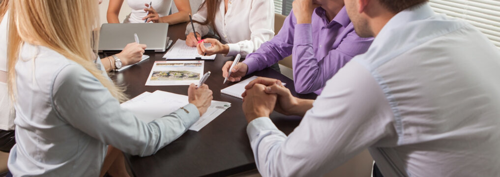 Panoramic view group of business people at work. Close-up employers hands.
