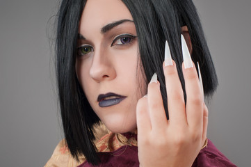 Fototapeta na wymiar Gothic woman with chinese nails / Dark gothic woman with cloak and chinese nails
