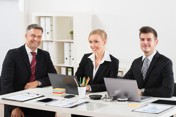 Group Of Businesspeople Sitting At Desk