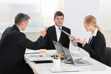 Two Businesspeople Quarreling To Young Businessman