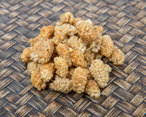 Dried white mulberry over wicker background