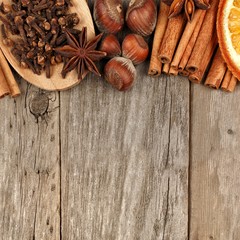 Top border of holiday spices and baking ingredients over a rustic wooden background